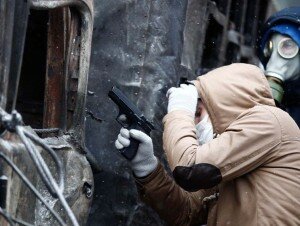 A pro-European protester holds a pneumatic gun during clashes with Ukrainian riot police in Kiev